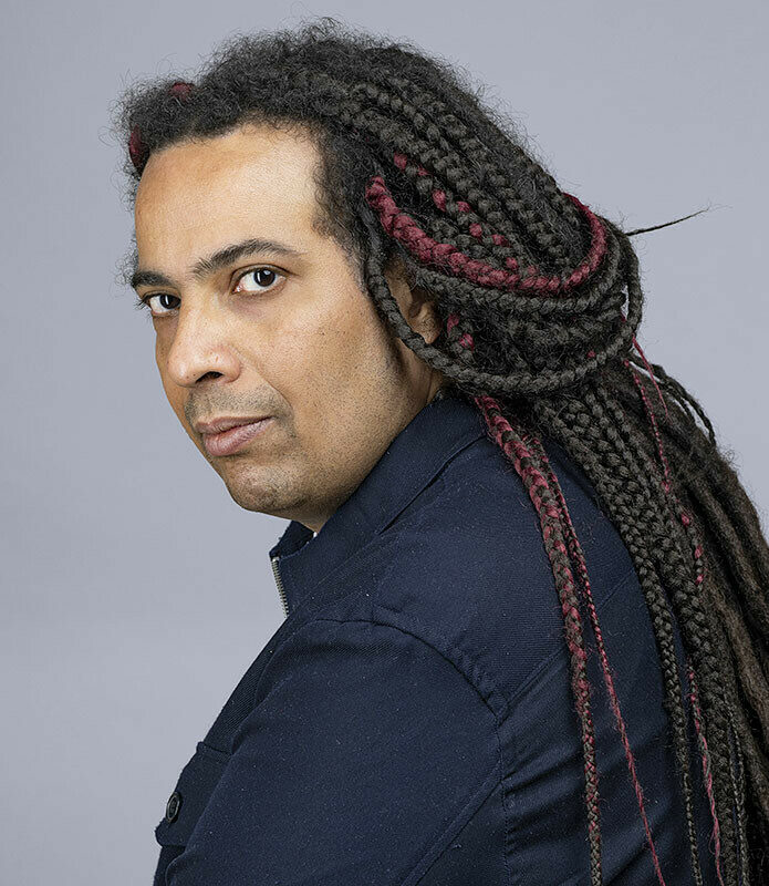 Un homme avec des dreadlocks, vu de trois quarts